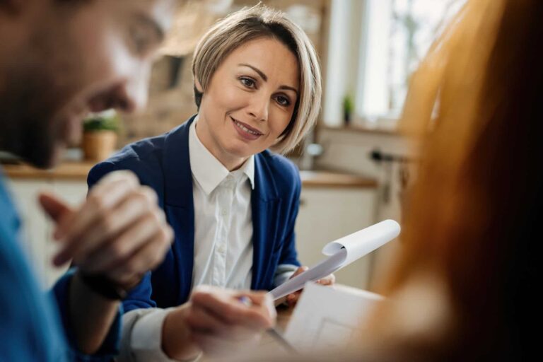 smiling-financial-advisor-talking-to-her-clients-during-a-meeting