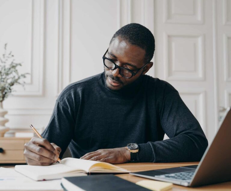 stunning-concentrated-aframerican-male-lawyer-in-casual-wear-making-notes-in-agenda